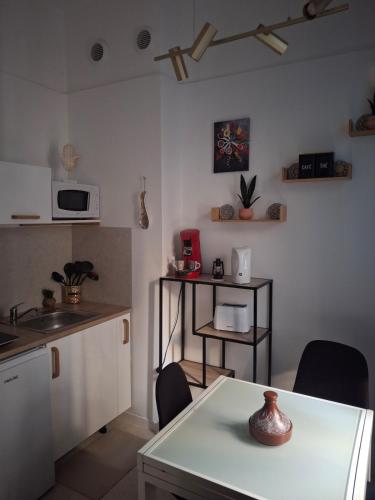 une cuisine avec une table et des chaises et un micro-ondes dans l'établissement Marrakech comes to Toulouse, à Toulouse