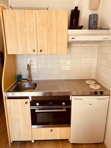 une petite cuisine avec un évier et une cuisinière dans l'établissement Samoëns 1600 au pied des pistes, à Samoëns