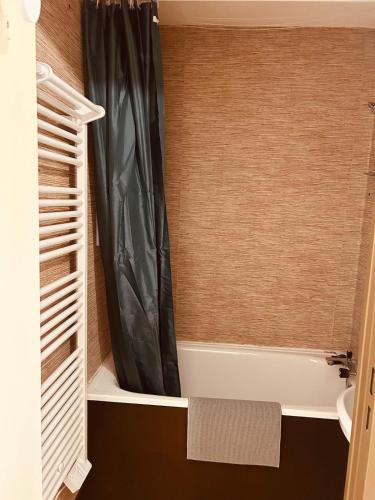 La salle de bains est pourvue d'un rideau de douche et d'une baignoire. dans l'établissement Samoëns 1600 au pied des pistes, à Samoëns