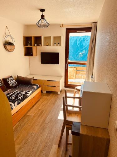 Cette chambre comprend un lit et un bureau avec une fenêtre. dans l'établissement Samoëns 1600 au pied des pistes, à Samoëns