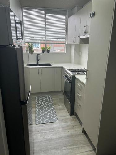 a kitchen with white cabinets and a black stove at Chic Retreat in Granville - steps to train ! in Clyde