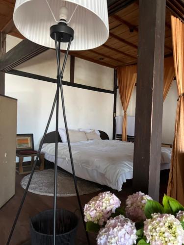 a bedroom with a bed in a room with flowers at 琴ヶ浜琴風亭 in Ōda