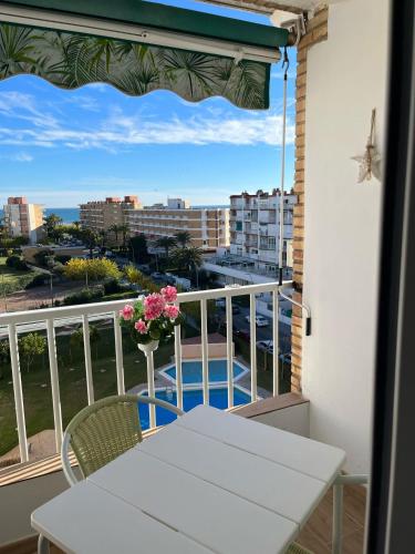 a balcony with a table and a vase of flowers at EL PISET in La Pineda