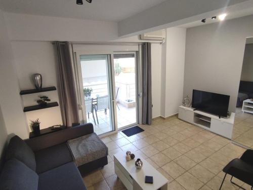 FaraíAmmos Seaside Apartment - 100 metres from the sea的客厅里有一张沙发和一台电视