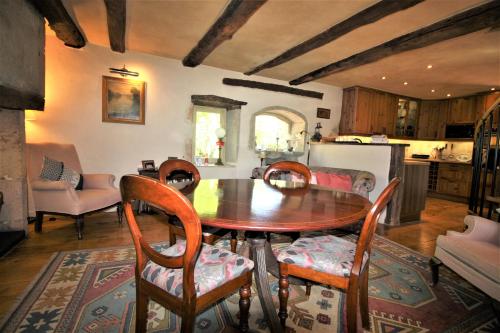 a dining room with a wooden table and chairs at Moulin de Bordes in Loze