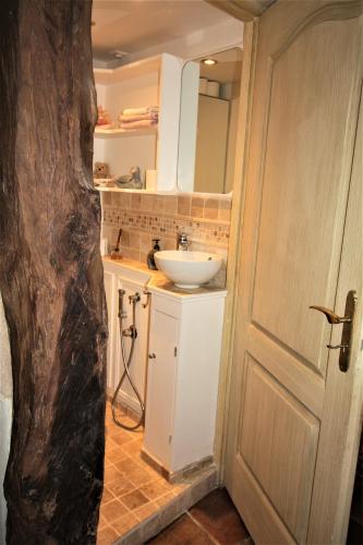 La salle de bains est pourvue d'un lavabo et d'un lavabo blanc. dans l'établissement Moulin de Bordes, à Loze