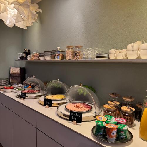 a buffet with several plates of food on a counter at Hotel Milú in Ludwigsburg