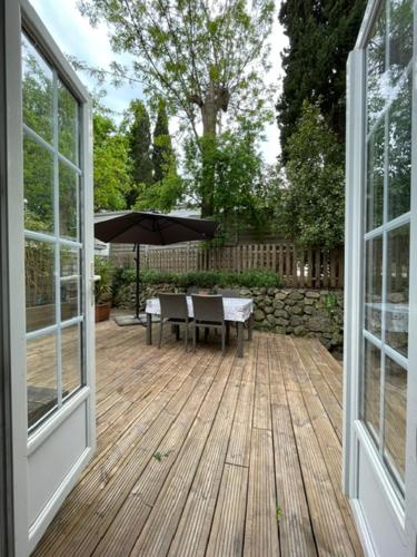 an open porch with a table and an umbrella at Mobil-home 4 Couchages Parking gratuit in Villeneuve-Loubet