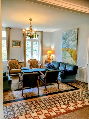 a living room with a couch and a table at Villa des glycines et Spa in Cempuis