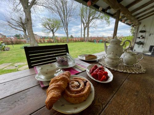 - une table avec petit-déjeuner composé de croissants et de fraises dans l'établissement Maison Rose, à Dognen