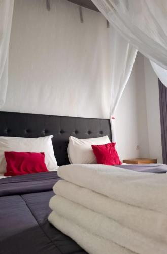 a bedroom with two beds with red pillows at Guest House d Valeri in Labuan Bajo