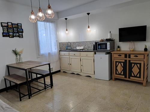 une cuisine avec une petite table et un micro-ondes dans l'établissement Bel appartement 2/4personnes, à Douzens