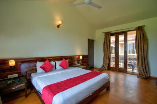a bedroom with a large bed with red pillows at Aveeno Resort & Villas Near Calangute and Baga in Jāmb
