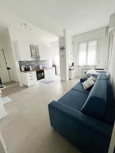 a living room with a blue couch and a kitchen at Suite Tra il Centro e il Mare,Vicino Stazione in Savona