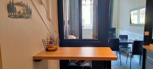 une table en bois avec un vase au-dessus dans l'établissement Côté Jardin la belle époque, à La Bourboule