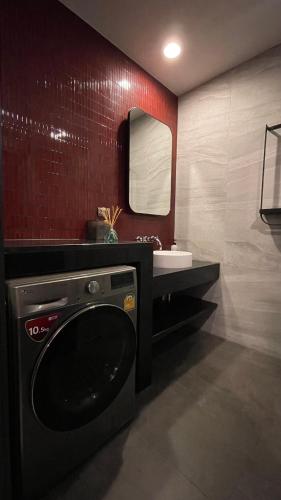 a bathroom with a sink and a washing machine at UTrip # EDGE CENTRAL PATTAYA in Pattaya