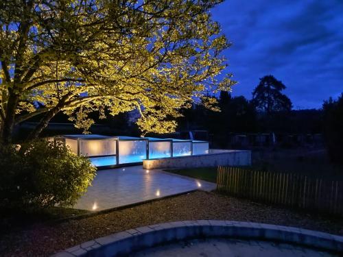 a building with lights on it at night at Village Collection Le Vauvert in Ormoy-la-Rivière