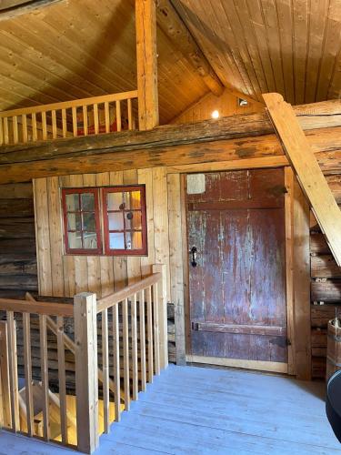 a room with a wooden door in a cabin at Låven på Selsvoll in Seljord