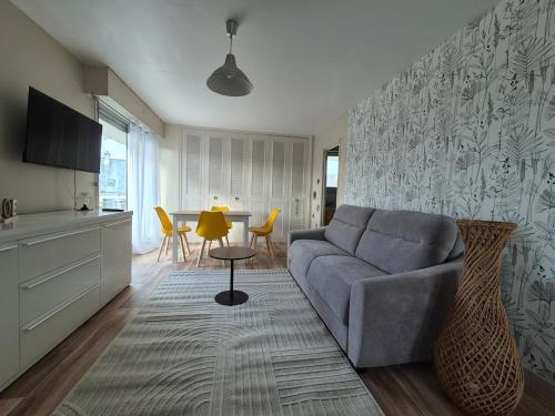 a living room with a couch and a table at L'ancre du Port in Saint-Quay-Portrieux