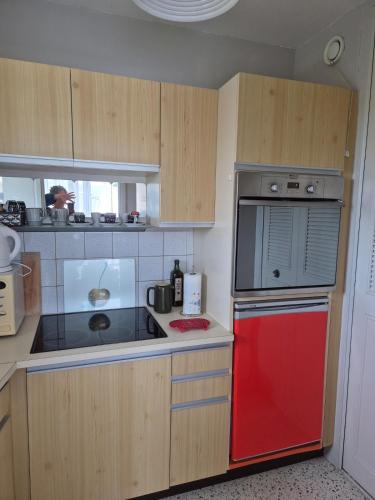 une cuisine avec un réfrigérateur rouge et un four rouge dans l'établissement L'ancre du Port, à Saint-Quay-Portrieux
