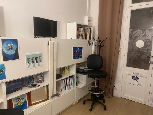 une pièce avec un bureau avec une chaise et des étagères dans l'établissement Loge, Studio facing Gare du Nord, à Paris