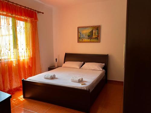 a bedroom with a bed with two towels on it at Haxhialiu Villa in Berat