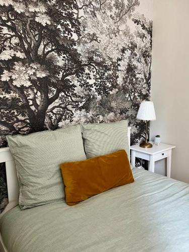 a bedroom with a bed with a tree mural on the wall at Les Capucines in Rouen