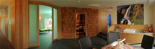 a living room with wood paneled walls and a room with a table at Hotel Tauernstern in Winklern