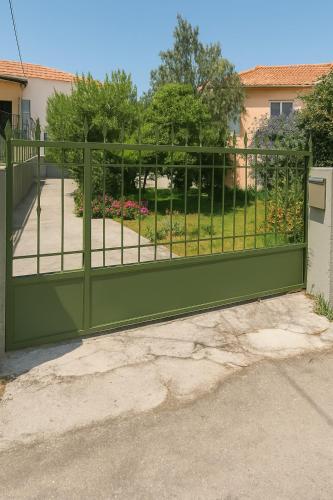 a green gate with a garden behind it at Petrochori Memories Maisonette in Petrochori