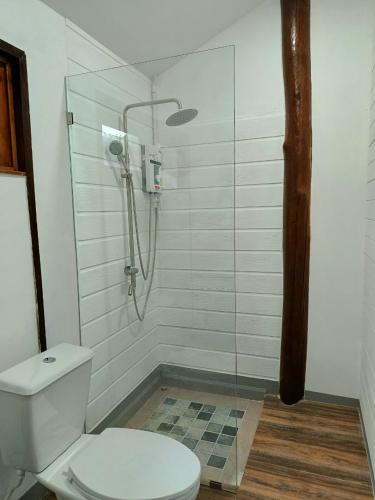 a bathroom with a shower with a toilet and a glass door at MAE-TON LUANG Camping in Ban Pang Haen