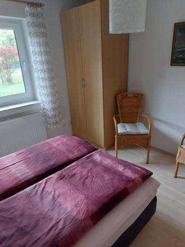 a bedroom with a large purple bed with a chair at Ferienwohnung Ahausen in Ahausen