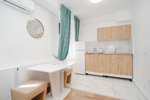 a kitchen with a table and a clock on the wall at Boutique Hotel Palas 500m Walking Distance in Iaşi