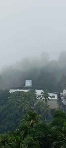 a foggy view of a city with trees and buildings at Residence Balanagala View Kandy in Katugastota