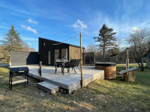 a house with a table and chairs on a deck at Paluküla tiny house Kadaka in Paluküla
