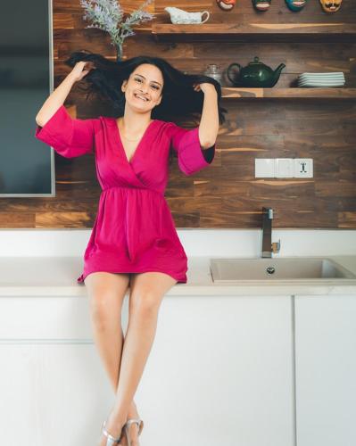 a woman in a pink dress sitting on a kitchen counter at River Arc Bolgoda Villa in Panadura