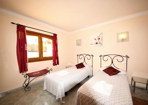 Un dormitorio con dos camas y una ventana en Your Island Villa Son Serra, en Son Serra de Marina