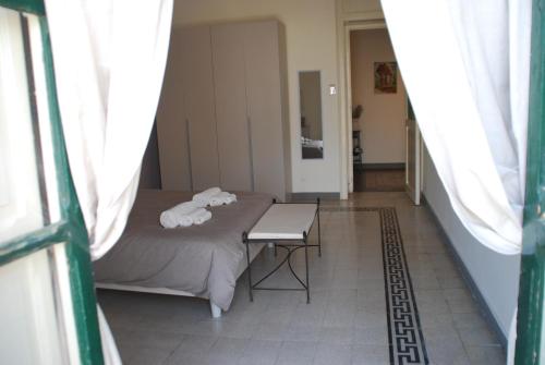 アグリジェントにあるCasa di nonna Ginaのベッド、テーブル、窓が備わる客室です。