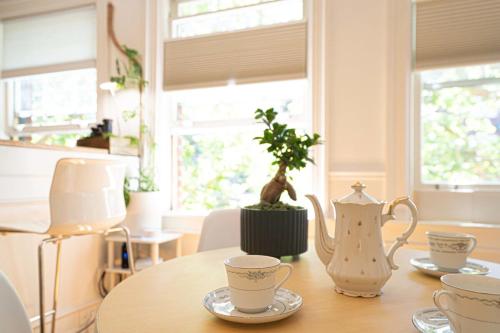 a table with two tea cups and a potted plant on it at Zen Gem Studio Downtown in Seattle