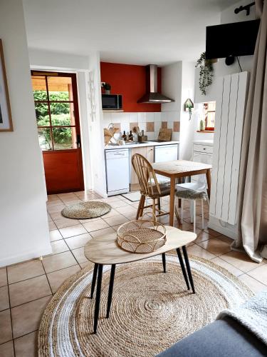 une cuisine avec une table et des chaises dans une pièce dans l'établissement Studio vue montagnes RDC piscine, à Cauterets