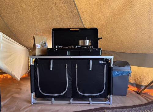 a table with a blender and a trash can at Camping Fuussekaul in Heiderscheid