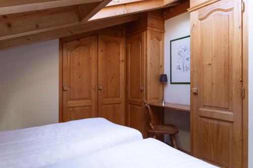 a bedroom with wooden cabinets and a bed and a desk at Hotel Montpelier in Verbier