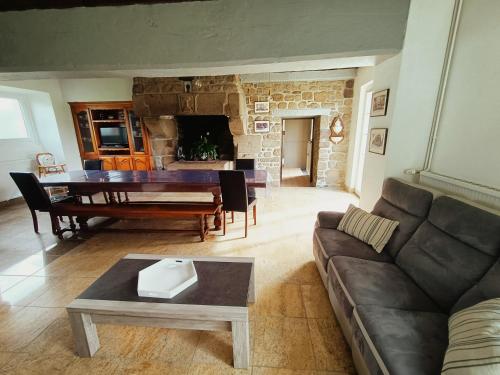 - un salon avec un canapé, une table et une cheminée dans l'établissement La trouvaille des retrouvailles, à Saint-Marc-le-Blanc