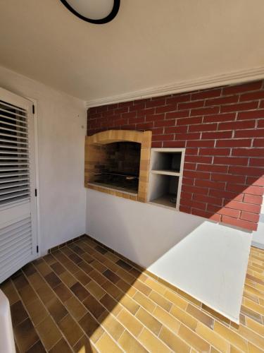 a living room with a brick fireplace on the wall at Villa Kaktusa in Pirovac