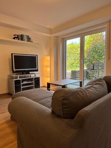 a living room with a couch and a flat screen tv at Charmante Ferienwohnung - Studio - an der Obernbreiter Kanzel - 50 m bis zu den Weinbergen in Obernbreit