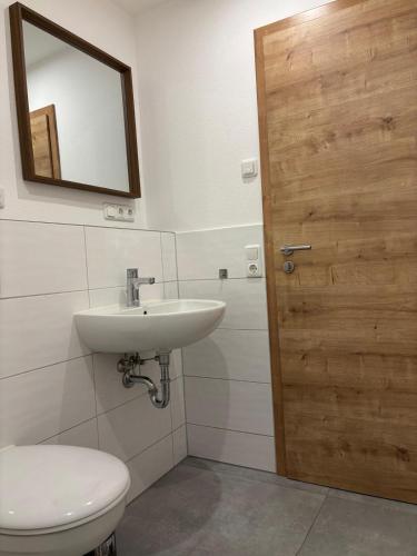 a bathroom with a toilet and a sink and a mirror at Charmante Ferienwohnung - Studio - an der Obernbreiter Kanzel - 50 m bis zu den Weinbergen in Obernbreit