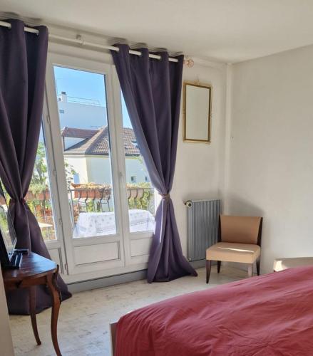 - une chambre avec un lit et une fenêtre avec des rideaux violets dans l'établissement Cosy F1 Parking privé, à Saint-Maur-des-Fossés