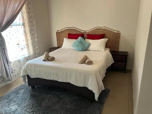 a bedroom with a large bed with slippers on it at AS contractors accommodation in Bronkhorstspruit