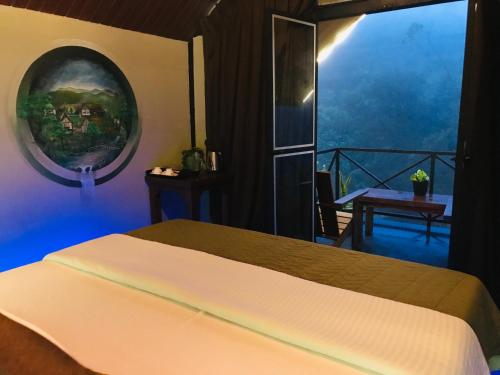 a bedroom with a bed and a window with a view at Grounder's River Cabin in Nuwara Eliya