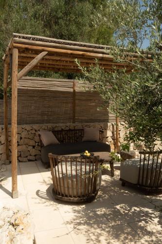 a patio with a bench and a wooden pergola at Tenuta Negroamaro in Gallipoli