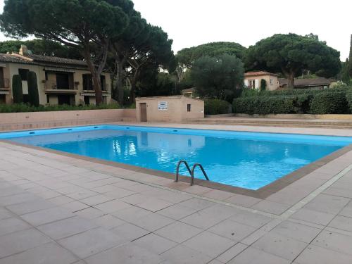 une piscine avec de l'eau bleue dans une cour dans l'établissement Le Castillon, à Roquebrune-sur Argens